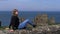 Girl relaxes on the wall at Dunluce Castle in North Ireland