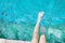 girl relaxing feet with water in the pool.