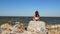 Girl relaxing on stone near sea