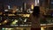 Girl resting on the balcony enjoying a breathtaking view of the big night city with many lights. Evening view of the Petronas Towe