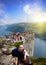 A girl resting on in Norway mountains , with people on a Preacher`s Pulpit Rock of a Lysefjord