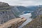 Girl resting on Trolltunga rock. Norwegian mountain landscape