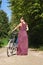 Girl with retro bicycle on a forest road, rear view