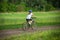 Girl ride on bike on rural landscape