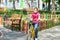 Girl rides a bicycle near the playground in a medical mask