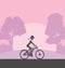 The girl rides a bicycle during sunrise