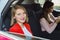 Girl rides in car with friend busy with smartphone