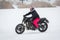 A girl rides a motorcycle on a frozen lake