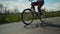 Girl rides a red bike on the asphalt path in the country