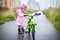 Girl rides a small Bicycle on a wet road