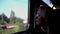 A girl rides a train sitting at the window and looks at the landscape