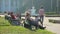 Girl riding bicycle car in park. People having rest on benches. Summer relax