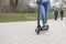 Girl riding a electric scooter in the park road with an action camera. Technological eco-friendly transport. Modern