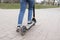 Girl riding a electric scooter in the park road. Technological eco-friendly transport. Modern active lifestyle