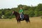 Girl riding horse in field