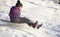 Girl riding on snow slides in winter time