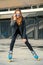 Girl on rollerblades standing in building background.