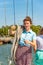 A girl with a rope on the deck of a yacht looks around, and holds the trunks on her shoulder.