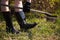 Girl in rubber boots with shovel and rake