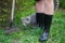 Girl in rubber boots with shovel and rake