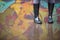 Girl in rubber boots standing in the puddle in the street. Woman in grey rubber boots splashing in a puddle after rain