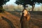 A girl in rubber boots walks through the forest and holds a magnifying glass in her hands, examines the stones, a mineral.