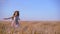 Girl running on golden wheat field, slow motion