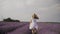 girl running on a lavender field in summer at sunset. Flowering bushes of Provence lavender and a young woman. Lady in a