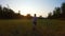 Girl running on meadow grass at sunset