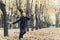 A girl running through the park and enjoys autumn, beautiful nature with yellow leaves