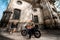 Girl running to her boyfriend sitting on the motorcycle in the old city, general plan