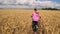 Girl runs across the field of wheat