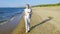 Girl runs along the sandy beach at dawn. Jogging on the seashore at sunset