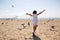 Girl runs on the beach dispersing birds seagulls