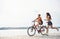 Girl runs near bicycle. Two female friends on the bike have fun at beach near the lake