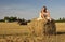 Girl in a rural clothing sitting on the haystack