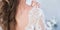 The girl`s back with not buttoned wedding dress. Morning of the bride. Wedding lace on a dress