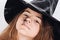 Girl`s face in witch hat with spider halloween direct look