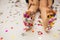 Girl`s feet in colorful confetti stars