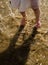 Girl`s feet in the sandy sea water jumping and splashing