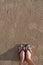 Girl`s feet wearing sandals Which stood on the sand on the beach