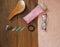 Girl`s hair care items on a wooden table. Bottle of shampoo, metal clips, brush, pink towel, elastic bands