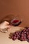 Girl`s hand keeps wineglass with red wine on bunch of grapes background. Wine time. Relax. Good evening