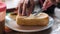 A girl`s hand slicing a piece of bread on a plate.