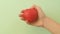 Girl`s hand squeezes red anti-stress heart toy.