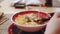 Girl`s hand takes a spoon with Japanese soup. Close up and focused view.