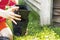 girl\'s hands stack empty plastic containers for flowers, after planting plants.