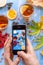 Girl`s hands with telephone, photographs composition with tea and fruit.