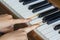 Girl\'s hands two fingers holding pressed keys on a piano