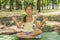 girl& x27;s happy and Meditate on the practice of yoga in the park , yoga kid. Healthy lifestyle - little girl doing yoga in the